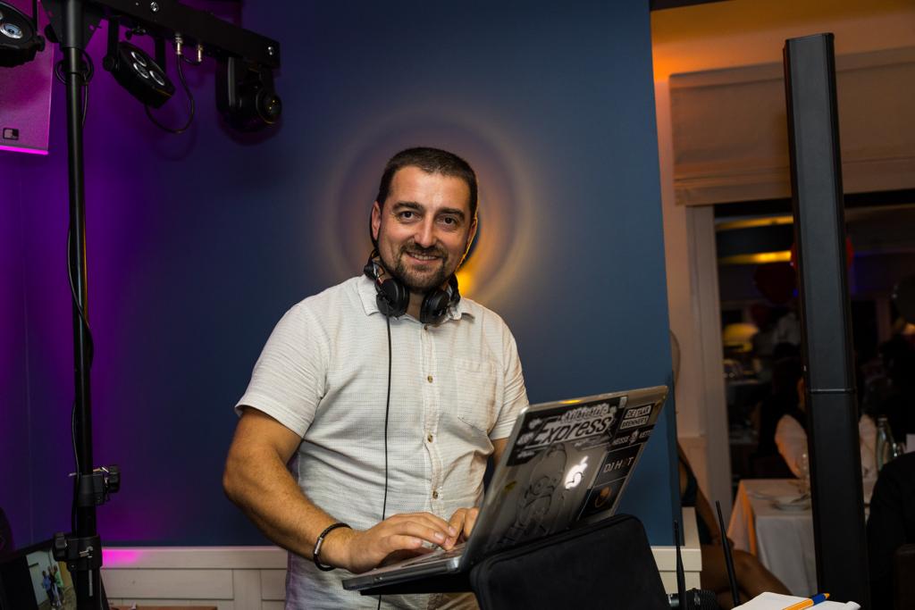 Portrait von DJ Senad Hot hinter dem DJ-Pult mit warmer Lichtstimmung
